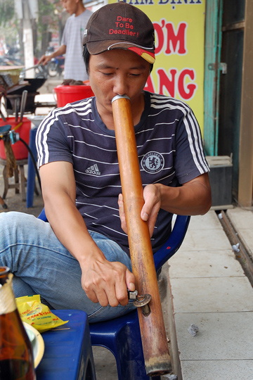 Quan lighting up a traditional water-pipe.