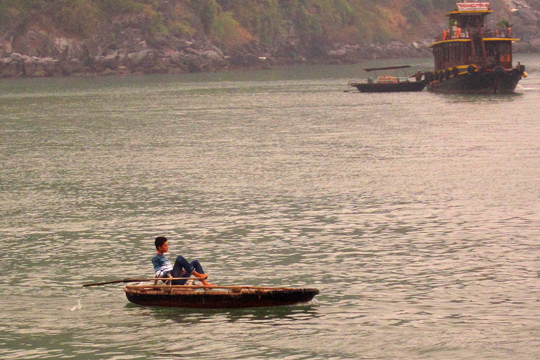 Rowing with his feet in Cat Ba Town harbour.