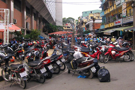 Valet  parking for customers' motorcycles. An Dong Market, Saigon.