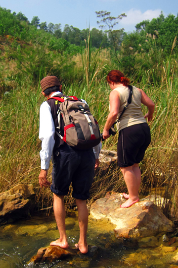 Mr. Tu helping Eron across the slippery rocks near Blood Falls.