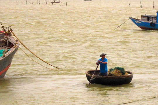 Using a traditional round row-boat, fishing village near Hoi An.