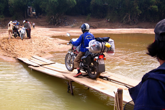 Mr. Tu rides off the river-ferry, Central Highlands.