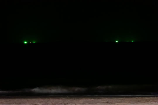 Fishing boats on the horizon.