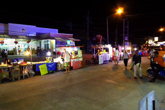 Food carts/stands set up on the middle of the road.